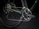 Close-up of Trek Checkpoint ALR 5 - Cross Bar 54" drivetrain, gears, and rear wheel in dark scene.