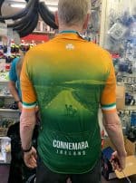 Man wearing Connemara Ireland Cycling Jersey, with scenic Irish road and sheep on the back.
