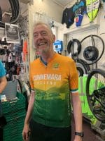 Smiling man in a Connemara Ireland Cycling Jersey stands in an Ireland bike shop.