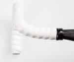 White Bontrager Perf Line Handlebar Tape Set on handlebar with black stem, light background.