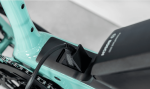 Close-up of an Allant+ 5 Lowstep Blue Sage e-bike battery being charged with a black cable.