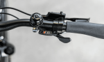 Close-up of an Allant+ 5 Lowstep Blue Sage handlebar with a bell and numbered gear changer.