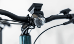 Close-up of Allant+ 5 Lowstep Blue Sage handlebar with headlamp and digital display.