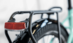 Close-up of an Allant+ 5 Lowstep Blue Sage bike’s rear rack, mudguard, and red reflector.