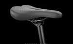 Close-up of a black, perforated saddle on the Dual Sport 1 Gen 4, mounted on a seatpost.