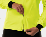 Person zipping up a bright yellow Trek Circuit Women's Rain Cycling Jacket with black cuffs.