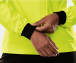 Person adjusting the sleeve of a neon yellow Trek Circuit Women’s Rain Cycling Jacket with black cuffs.