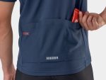 Person puts a red energy bar in the back pocket of a blue Trek Solstice Cycling Jersey Medium.