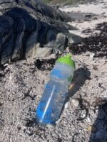 Clifden Bike Shop Water Bottle on sandy beach.
